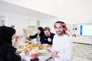 junger arabischer mann, der iftar-abendessen mit muslimischer familie hat foto