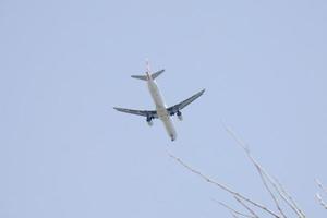 Verkehrsflugzeuge, die unter blauem Himmel fliegen und am Flughafen ankommen foto