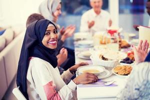 schwarze moderne muslimische frau, die iftar-abendessen mit der familie genießt foto