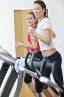 Frauentraining im Fitnessclub auf der Laufstrecke foto