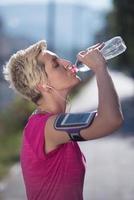 Frau Trinkwasser nach dem Joggen foto