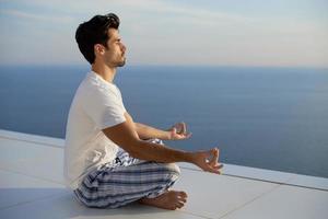 junger Mann, der Yoga praktiziert foto