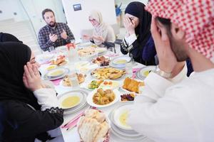 traditionelle muslimische familie, die vor dem iftar-abendessen betet foto