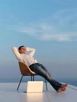 Entspannter junger Mann zu Hause auf dem Balkon foto