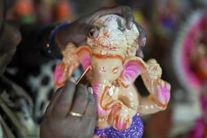 künstler, der ganesh-idol aus ton für das ganesha-fest herstellt - konzept der hindu-religiösen festvorbereitungen in indien foto