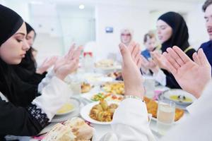 traditionelle muslimische familie, die vor dem iftar-abendessen betet foto