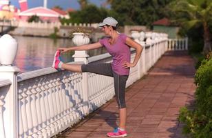 frau, die sich vor dem morgendlichen joggen dehnt foto