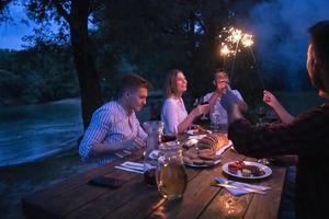 Freunde, die während der Sommerferien ein französisches Picknick im Freien haben foto