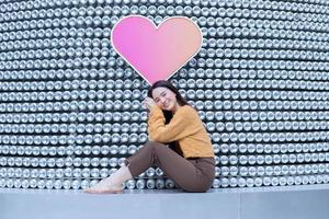 schöne asiatische frau im schwarzen langen haar trägt gelben mantel und frisches lächeln im valentinsthema. foto