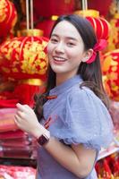 asiatische schöne frau im langen haar trägt ein graues chinesisches kleid oder qipao mit chinesischem neujahrsthema. foto
