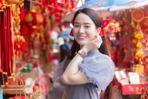 asiatische schöne frau im langen haar trägt ein graues chinesisches kleid mit chinesischem neujahrsthema. foto