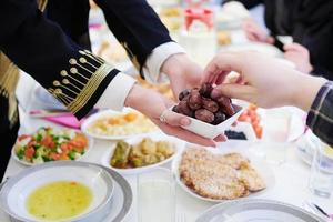 muslimische familie beim iftar-abendessen, das datteln isst, um das fest zu brechen foto