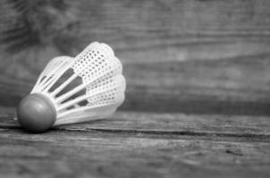 Federball zum Badmintonspielen auf einem Holzhintergrund in Schwarz und Weiß foto