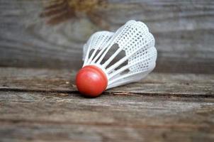 Federball zum Badmintonspielen auf Holzhintergrund, Minimalismus foto