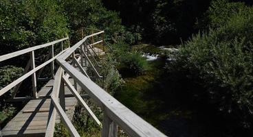 Holzbrücke über wilden Fluss foto
