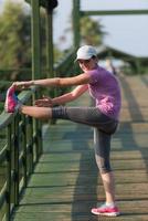 frau, die sich vor dem morgendlichen joggen dehnt foto