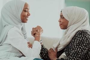 afrikanisches armwrestling-konfliktkonzept, uneinigkeit und konfrontation in traditioneller islamischer hijab-kleidung. selektiver Fokus foto