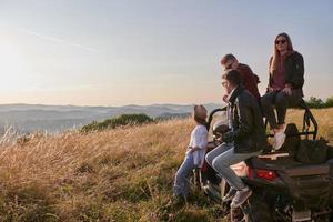 Gruppe junger glücklicher Menschen, die einen schönen sonnigen Tag genießen, während sie ein Offroad-Buggy-Auto fahren foto