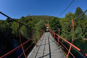 Holzbrücke über wilden Fluss foto