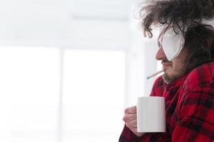 junger Mann mit Grippe und Fieber foto