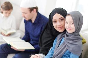 muslimische familie, die koran liest und zu hause betet foto