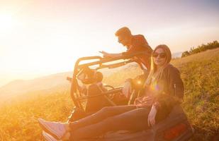 Gruppe junger Leute, die ein Offroad-Buggy-Auto fahren foto