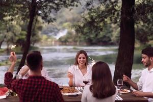 Freunde, die während der Sommerferien ein französisches Picknick im Freien haben foto