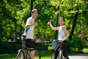 Glückliches Paar, das im Freien Fahrrad fährt foto