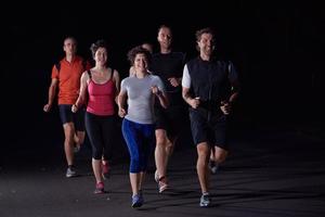 Menschengruppe joggt nachts foto