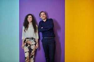 glückliches junges paar, das auf purpurrotem hintergrund aufwirft foto