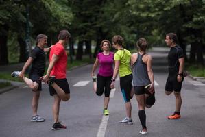 läuferteam beim aufwärmen und dehnen vor dem morgendlichen training foto