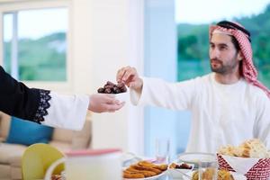 muslimische familie beim iftar-abendessen, das datteln isst, um das fest zu brechen foto