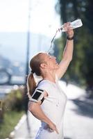 Frau Trinkwasser nach dem Joggen foto