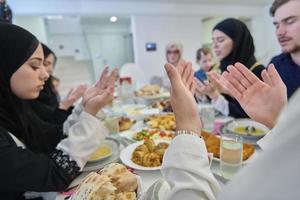 muslimische familie, die iftar dua macht, um während des ramadan das fasten zu brechen. foto