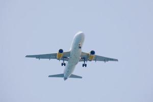 Verkehrsflugzeuge, die unter blauem Himmel fliegen und am Flughafen ankommen foto