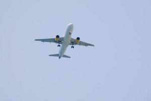 Verkehrsflugzeuge, die unter blauem Himmel fliegen und am Flughafen ankommen foto