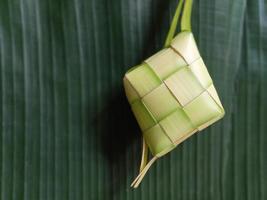 Ketupat oder Reisknödel ist eine lokale Delikatesse während der festlichen Jahreszeit. Ketupats, eine natürliche Reishülle aus jungen Kokosblättern zum Kochen von Reis isoliert auf weißem Hintergrund foto