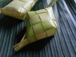 Ketupat oder Reisknödel ist eine lokale Delikatesse während der festlichen Jahreszeit. Ketupats, eine natürliche Reishülle aus jungen Kokosblättern zum Kochen von Reis isoliert auf weißem Hintergrund foto