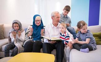 moderne muslimische großeltern mit enkelkindern, die den koran lesen foto