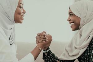 afrikanisches armwrestling-konfliktkonzept, uneinigkeit und konfrontation in traditioneller islamischer hijab-kleidung. selektiver Fokus foto