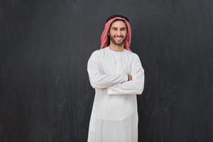junger muslimischer mann mit verschränkten armen lächelnd foto