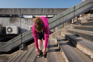 frau, die sich vor dem morgendlichen joggen dehnt foto