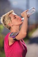Frau Trinkwasser nach dem Joggen foto