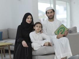 junge muslimische familie, die während des ramadan den koran liest foto