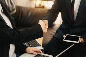 Business-Handshake, der einen Deal mit unscharfem Hintergrund von Menschen abschließt foto