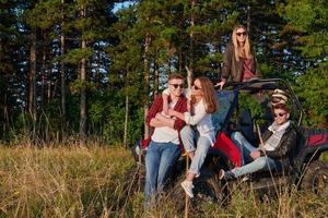 Gruppe junger glücklicher Menschen, die einen schönen sonnigen Tag genießen, während sie ein Offroad-Buggy-Auto fahren foto