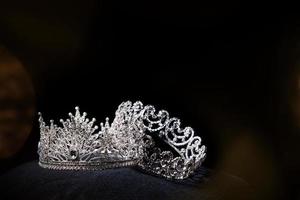 Diamant-Silberkrone für Miss-Schönheitswettbewerb, Kristall-Tiara-Schmuck verziert mit Edelsteinen und abstrakter dunkler Hintergrund auf schwarzem Samtstoff, Makrofotografie-Kopienraum für Textlogo foto