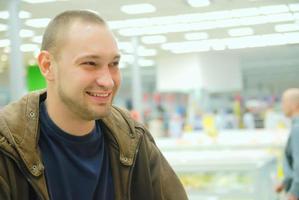 lächelnder Mann im Supermarkt foto