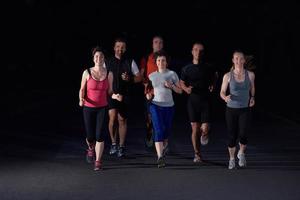 Menschengruppe joggt nachts foto