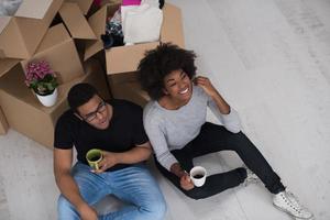 Afroamerikanisches Paar, das sich im neuen Haus entspannt foto